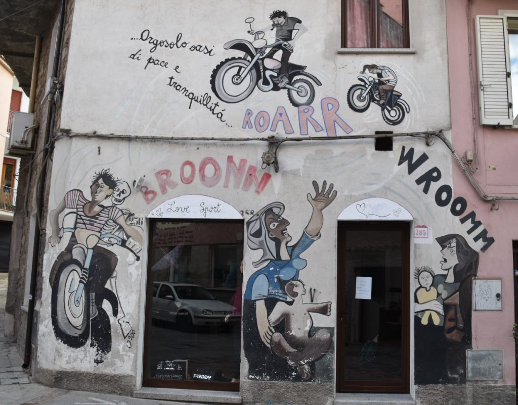 Orgosolo - an oasis of peace and tranquillity says the mural... contrasted with the pictures of roaring racing motorbikes...