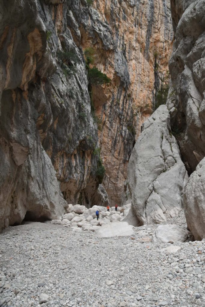 Hikers dwarfed by the giant walls of Gola Goroppu