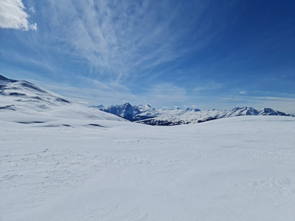 View across the plateau to distant peaks on the Dreibündenstein showshoeing trail